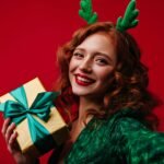 a woman wearing reindeer antlers holding a present